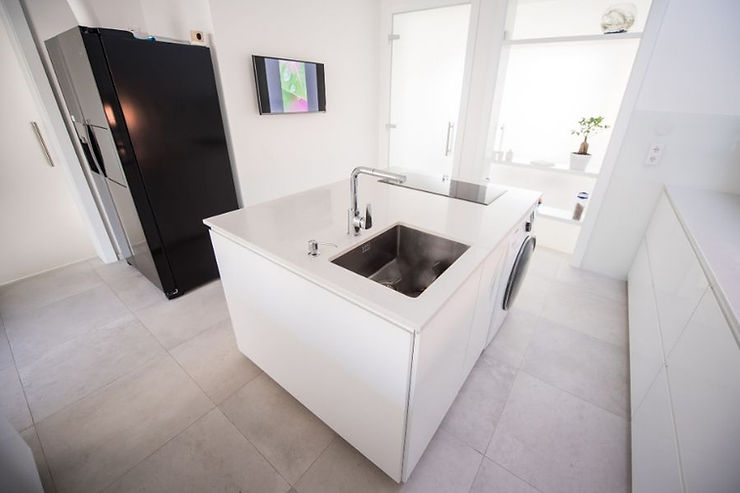 minimalist kitchen white island with sink, stovetop and washing machine