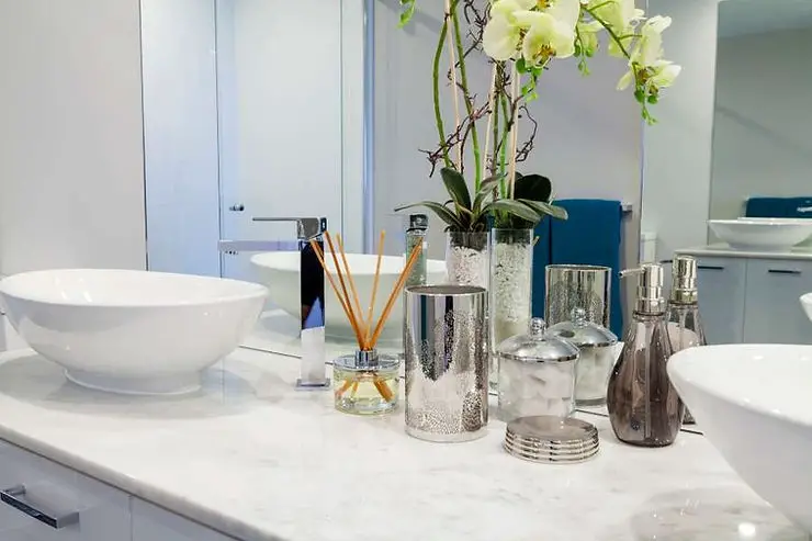 white minimalist bathroom with glass decorative vases and jars