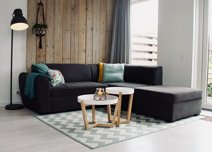 minimalist apartment living room wooden walls and black sofa