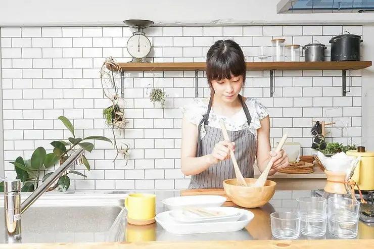 minimalist woman cooking in white cozy kitchen